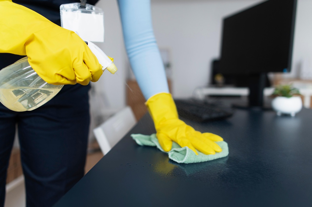 Schoonmaker van Sphinx Cleaning maakt een bureau grondig schoon